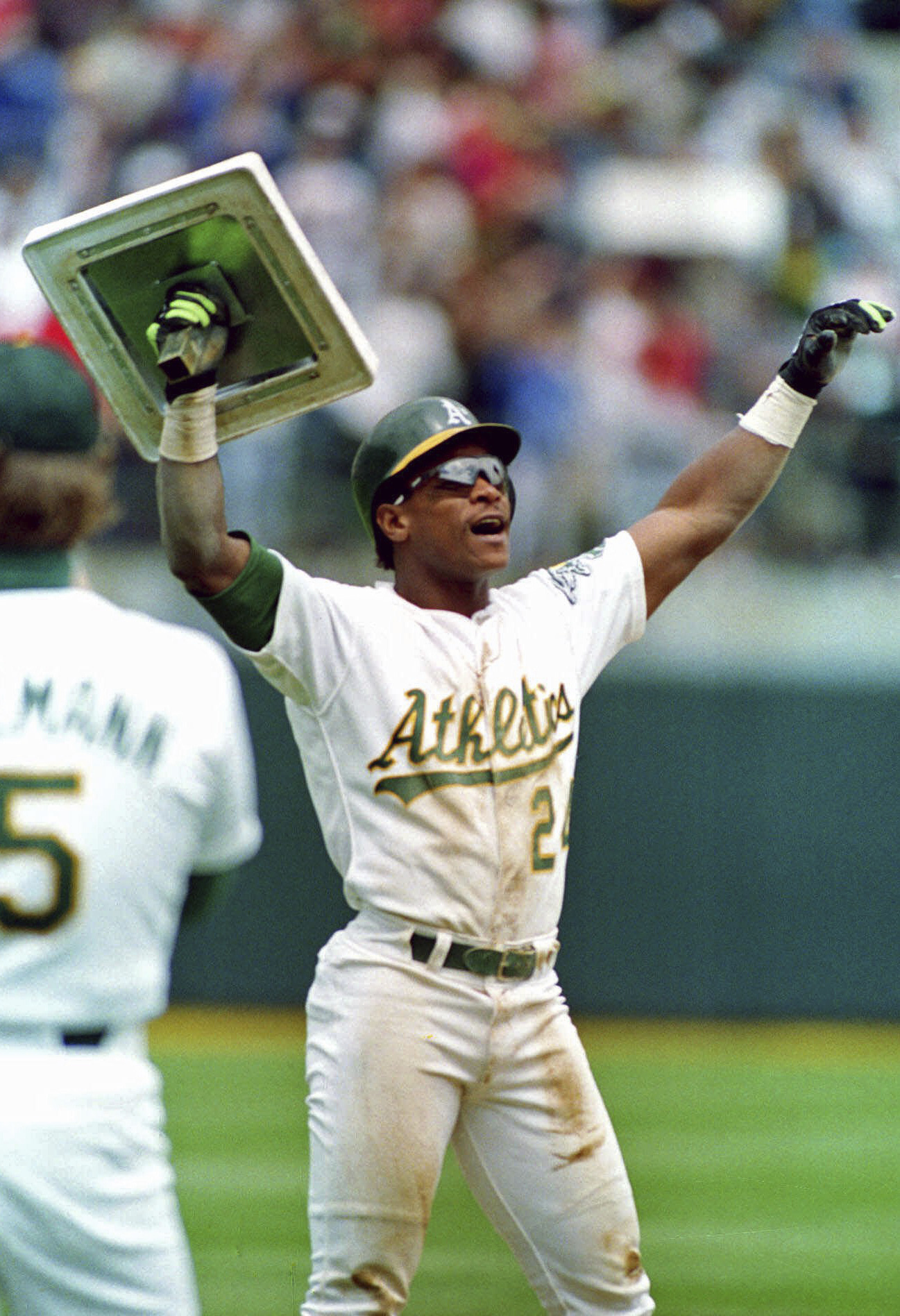 FILE - Oakland Athletics' Rickey Henderson holds up third base after breaking Lou Brock's all-time career record for stolen bases during the fourth inning of a baseball game against the New York Yankees in Oakland, Calif., May 1, 1991. (AP Photo/Alan Greth, File)