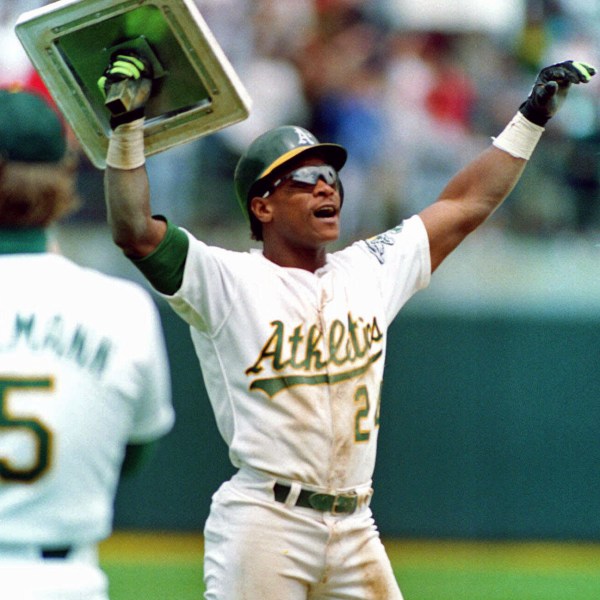 FILE - Oakland Athletics' Rickey Henderson holds up third base after breaking Lou Brock's all-time career record for stolen bases during the fourth inning of a baseball game against the New York Yankees in Oakland, Calif., May 1, 1991. (AP Photo/Alan Greth, File)