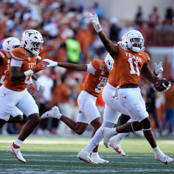 Texas linebacker Colin Simmons (11) celebrates with teammates after an interception during the first half against Clemson in the first round of the College Football Playoff, Saturday, Dec. 21, 2024, in Austin, Texas. (AP Photo/Eric Gay)