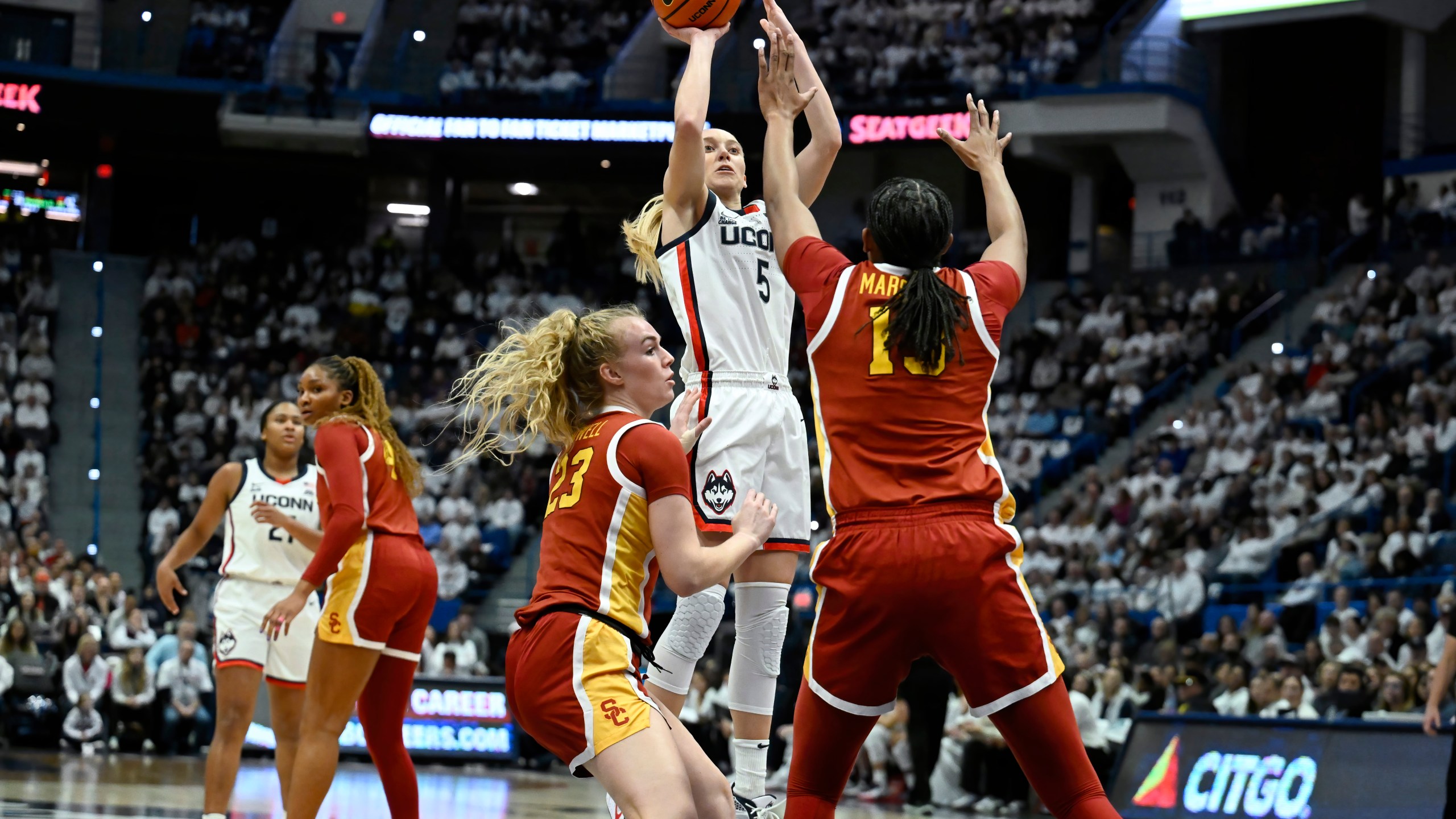 UConn guard Paige Bueckers (5) pulls up for a basket against Southern California guard Avery Howell (23) and center Rayah Marshall (13) in the first half of an NCAA college basketball game, Saturday, Dec. 21, 2024, in Hartford, Conn. (AP Photo/Jessica Hill)