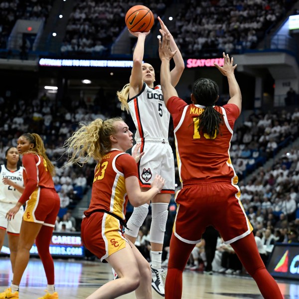 UConn guard Paige Bueckers (5) pulls up for a basket against Southern California guard Avery Howell (23) and center Rayah Marshall (13) in the first half of an NCAA college basketball game, Saturday, Dec. 21, 2024, in Hartford, Conn. (AP Photo/Jessica Hill)