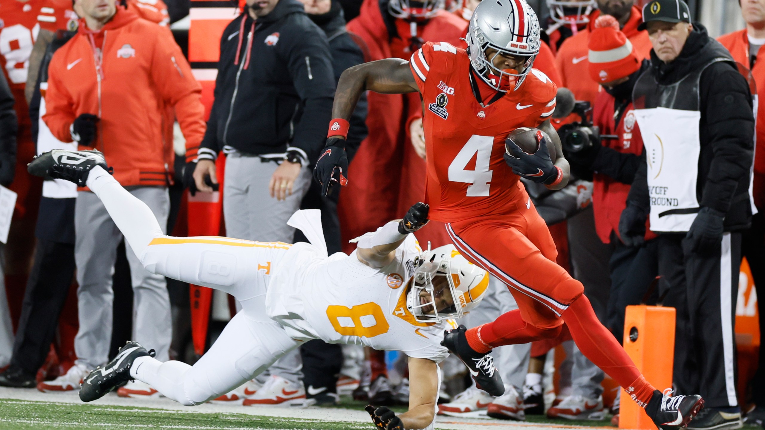 Tennessee linebacker Kalib Perry, left, forces Ohio State receiver Jeremiah Smith (4) out of bounds during the first half in the first round of the College Football Playoff, Saturday, Dec. 21, 2024, in Columbus, Ohio. (AP Photo/Jay LaPrete)