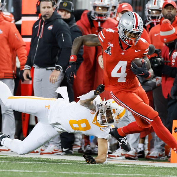 Tennessee linebacker Kalib Perry, left, forces Ohio State receiver Jeremiah Smith (4) out of bounds during the first half in the first round of the College Football Playoff, Saturday, Dec. 21, 2024, in Columbus, Ohio. (AP Photo/Jay LaPrete)