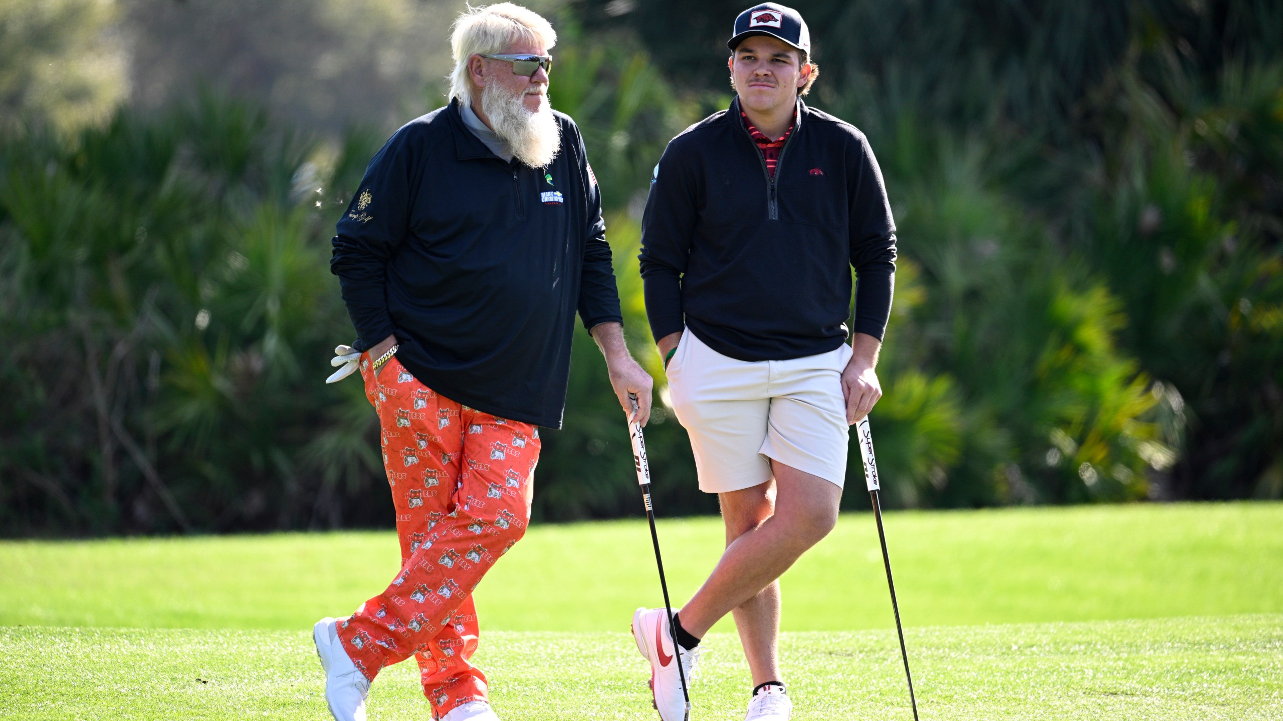 John Daly, left, and his son John Daly II wait to putt on the third green hole during the first round of the PNC Championship golf tournament, Saturday, Dec. 21, 2024, in Orlando, Fla. (AP Photo/Phelan M. Ebenhack)