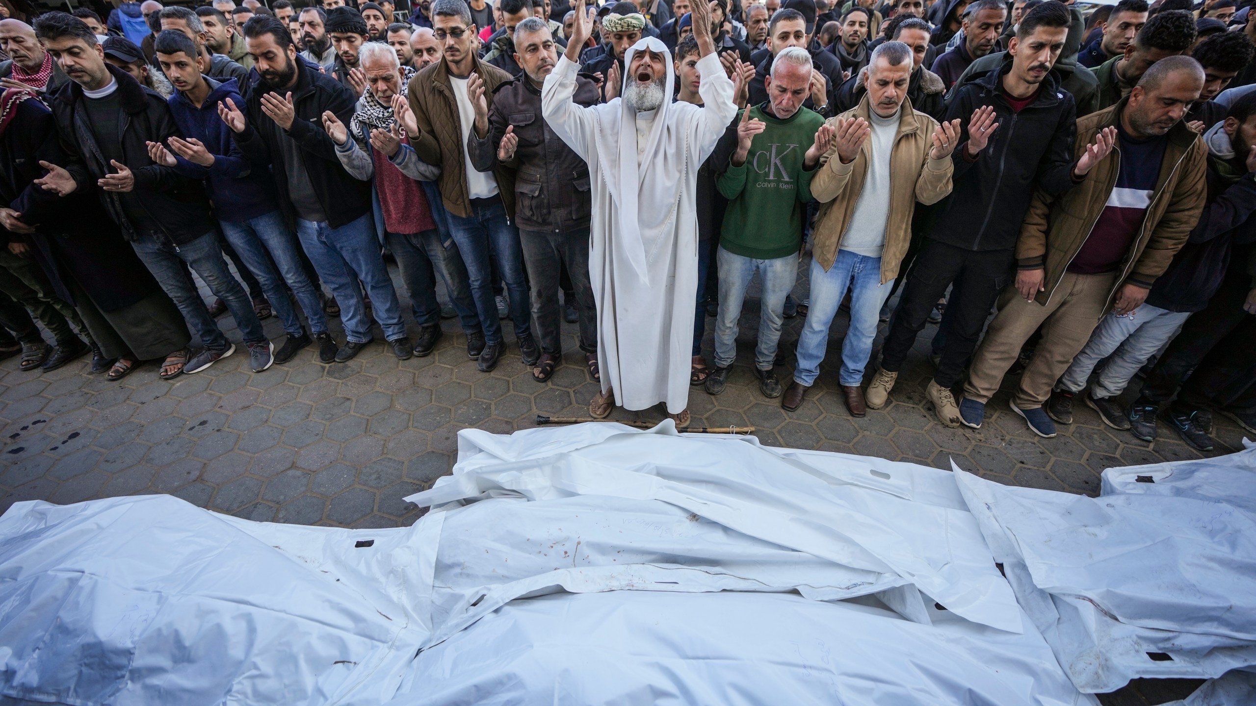 Palestinians pray over the bodies of the victims of an Israeli strike on a home late Saturday before the funeral outside the Al-Aqsa Martyrs Hospital in Deir al-Balah Sunday, Dec. 22, 2024. At least eight people were killed according to the hospital which received the bodies.(AP Photo/Abdel Kareem Hana)