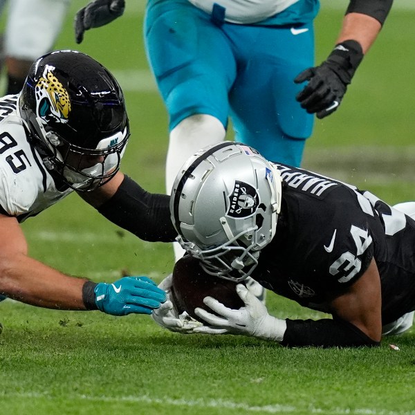 Las Vegas Raiders safety Thomas Harper (34) recovers a rumble against Jacksonville Jaguars tight end Brenton Strange (85) during the first half of an NFL football game Sunday, Dec. 22, 2024, in Las Vegas. (AP Photo/John Locher)