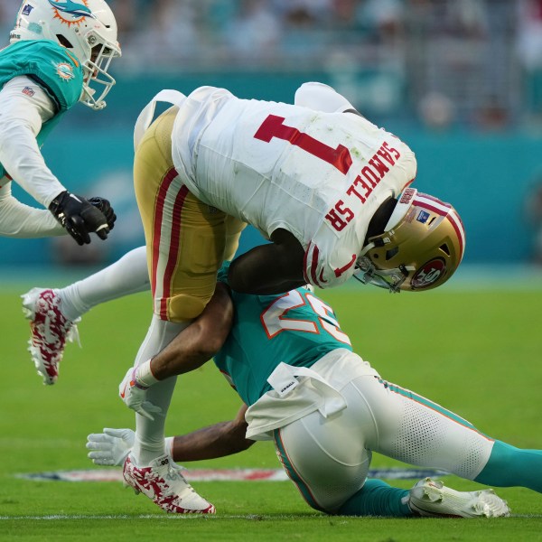 San Francisco 49ers wide receiver Deebo Samuel Sr. (1) is tackled by Miami Dolphins running back Jaylen Wright (25) during the first half of an NFL football game, Sunday, Dec. 22, 2024, in Miami Gardens, Fla. (AP Photo/Lynne Sladky)