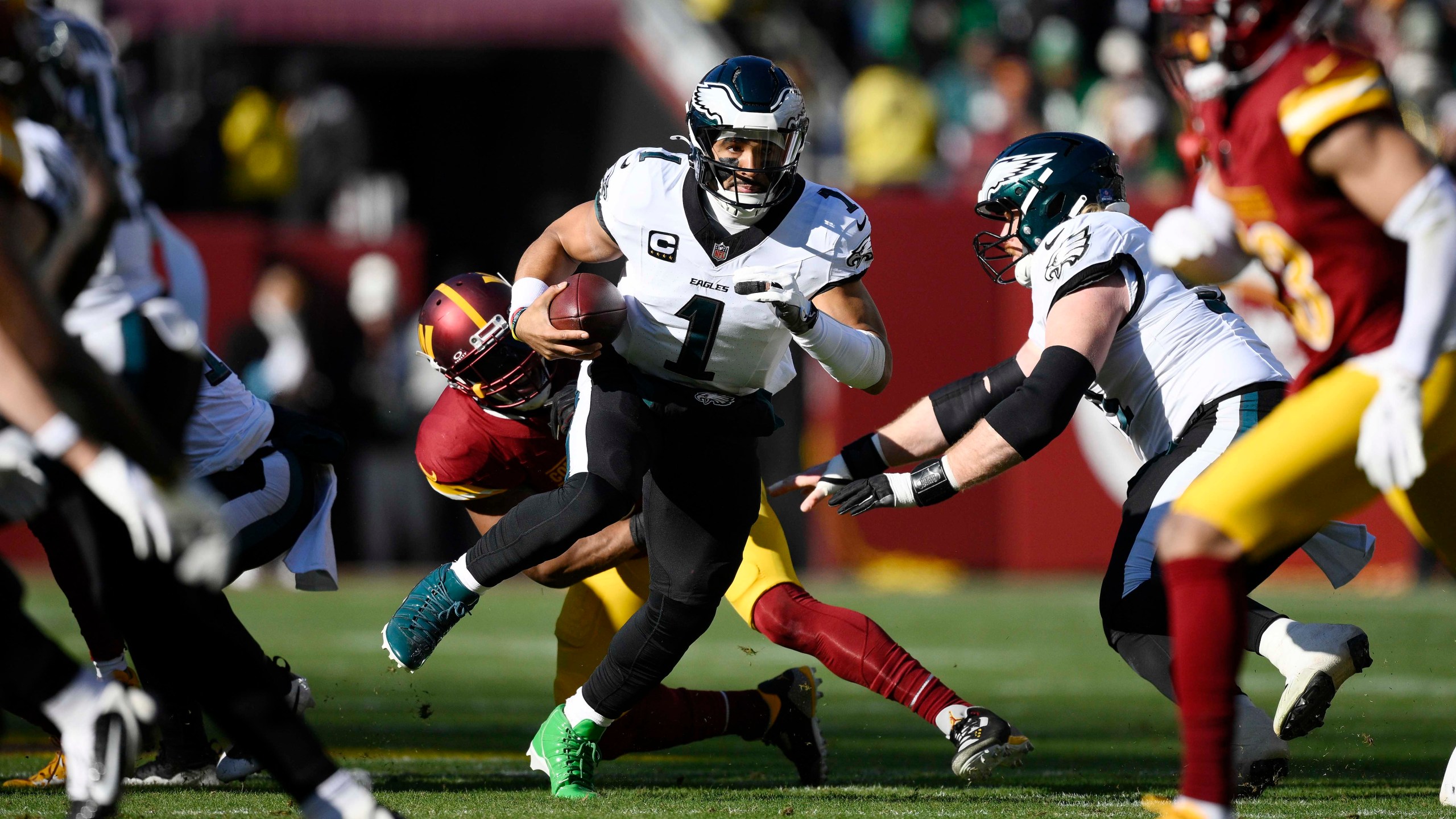 Philadelphia Eagles quarterback Jalen Hurts (1) scrambles as he carries the ball during the first half of an NFL football game against the Washington Commanders, Sunday, Dec. 22, 2024, in Landover, Md. (AP Photo/Nick Wass)