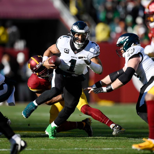 Philadelphia Eagles quarterback Jalen Hurts (1) scrambles as he carries the ball during the first half of an NFL football game against the Washington Commanders, Sunday, Dec. 22, 2024, in Landover, Md. (AP Photo/Nick Wass)