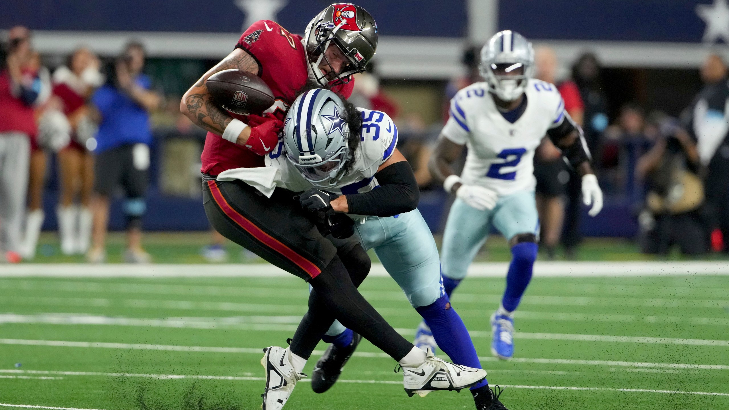 Tampa Bay Buccaneers tight end Payne Durham (87) is uanble to secure a pass as Dallas Cowboys linebacker Marist Liufau (35) delivers a hard hit in the second half of an NFL football game in Arlington, Texas, Sunday, Dec. 22, 2024. (AP Photo/Jeffrey McWhorter)