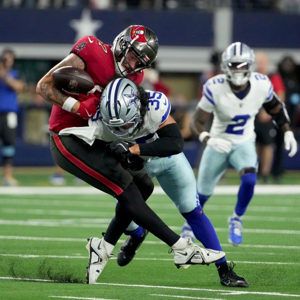 Tampa Bay Buccaneers tight end Payne Durham (87) is uanble to secure a pass as Dallas Cowboys linebacker Marist Liufau (35) delivers a hard hit in the second half of an NFL football game in Arlington, Texas, Sunday, Dec. 22, 2024. (AP Photo/Jeffrey McWhorter)