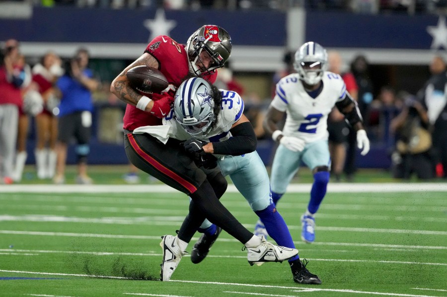 Tampa Bay Buccaneers tight end Payne Durham (87) is uanble to secure a pass as Dallas Cowboys linebacker Marist Liufau (35) delivers a hard hit in the second half of an NFL football game in Arlington, Texas, Sunday, Dec. 22, 2024. (AP Photo/Jeffrey McWhorter)