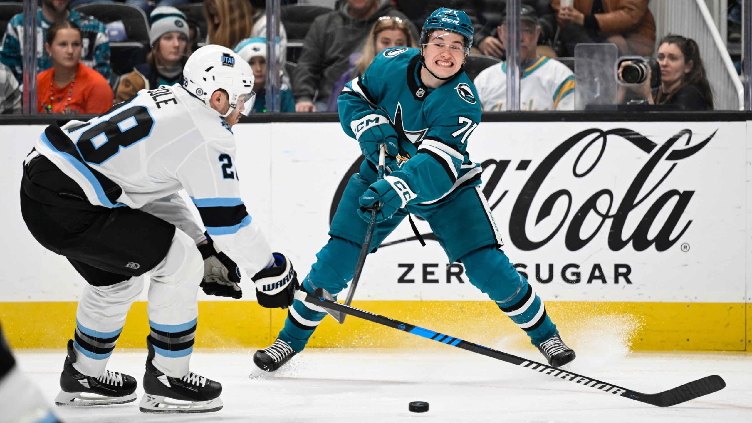 San Jose Sharks center Macklin Celebrini (71) crosses the puck against Utah Hockey Club defenseman Ian Cole (28) during the first period of an NHL hockey game Saturday, Dec. 14, 2024, in San Jose, Calif. (AP Photo/Eakin Howard)