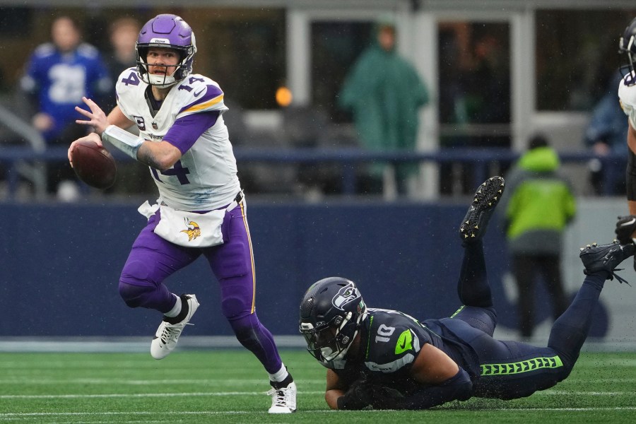 Minnesota Vikings quarterback Sam Darnold (14) scrambles as Seattle Seahawks linebacker Uchenna Nwosu (10) tries to tackle during the first half of an NFL football game, Sunday, Dec. 22, 2024, in Seattle. (AP Photo/Lindsey Wasson)