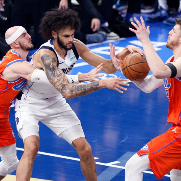 Oklahoma City Thunder center Isaiah Hartenstein, right, tries to steal the ball from Dallas Mavericks center Dereck Lively II, center, as Thunder guard Alex Caruso, left, defends during the first half of an Emirates NBA Cup basketball game, Tuesday, Dec. 10, 2024, in Oklahoma City. (AP Photo/Nate Billings)