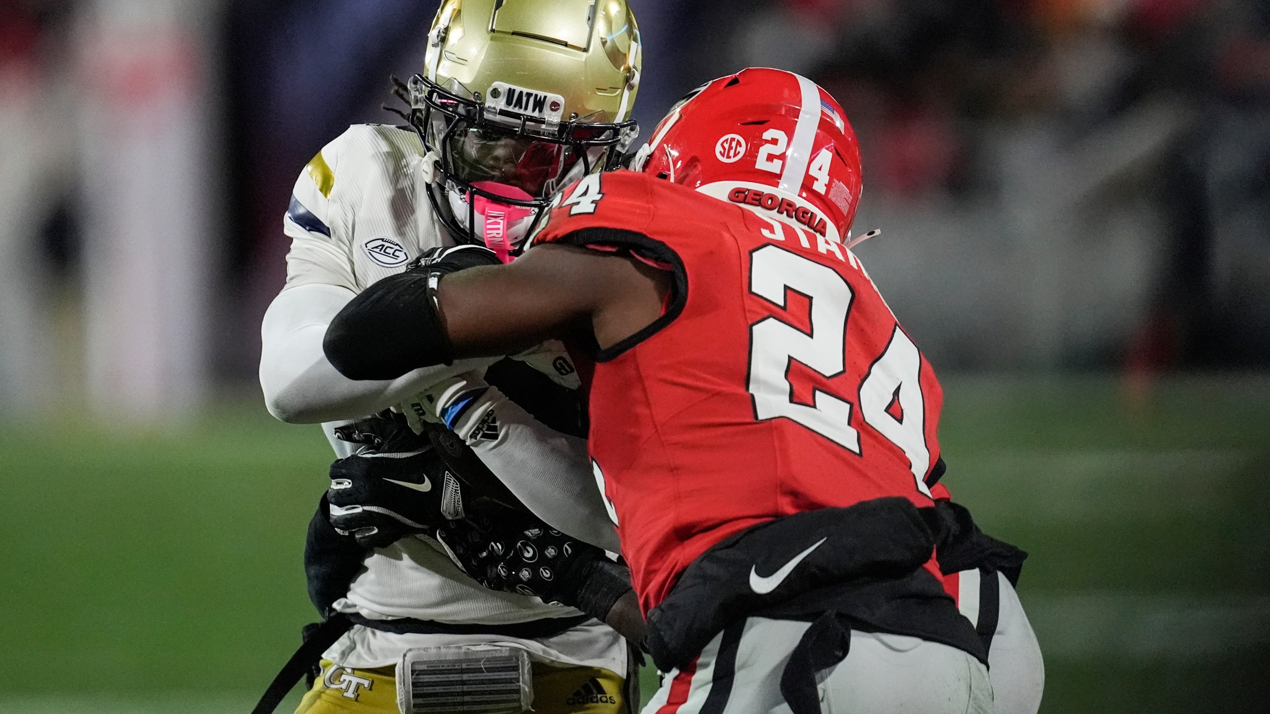 Georgia Tech wide receiver Eric Singleton Jr. (2) runs into Georgia defensive back Malaki Starks (24) during the first half of an NCAA college football game, Friday, Nov. 29, 2024, in Athens, Ga. (AP Photo/Mike Stewart)