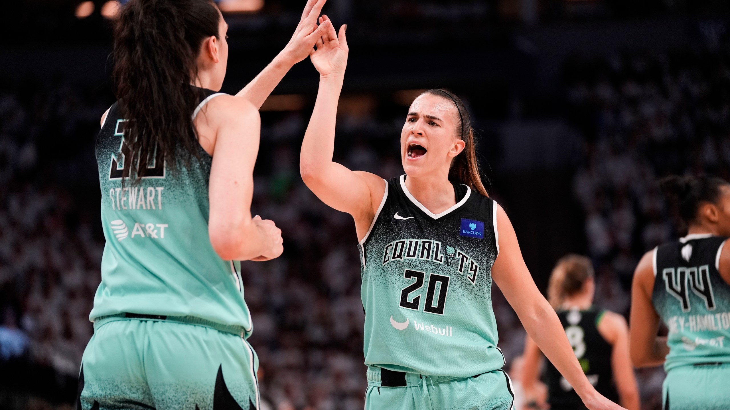 FILE - New York Liberty guard Sabrina Ionescu (20) reacts with forward Breanna Stewart (30) at the end of the first half of Game 4 of a WNBA basketball final playoff series against the Minnesota Lynx, Friday, Oct. 18, 2024, in Minneapolis. (AP Photo/Abbie Parr, File)