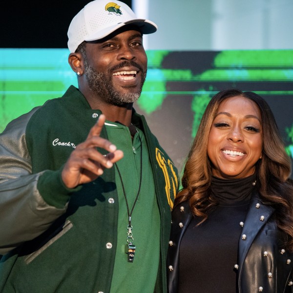 Michael Vick and his wife Kijafa Vick pose for a photo after he was named the next head coach of the Norfolk State University football team durning a press conference on Monday, Dec. 23, 2024 in Norfolk, Va. (AP Photo/Mike Caudill)