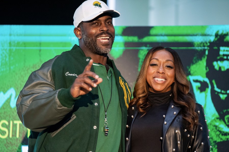 Michael Vick and his wife Kijafa Vick pose for a photo after he was named the next head coach of the Norfolk State University football team durning a press conference on Monday, Dec. 23, 2024 in Norfolk, Va. (AP Photo/Mike Caudill)