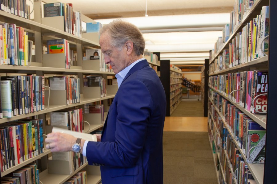 FILE - Nate Coulter, executive director of the Central Arkansas Library System (CALS), looks at a book in the main branch of the public library in downtown Little Rock, Ark., May 23, 2023. An increasing number of conservative states are pushing for measures making it easier to ban or restrict access to books. (AP Photo/Katie Adkins, File)