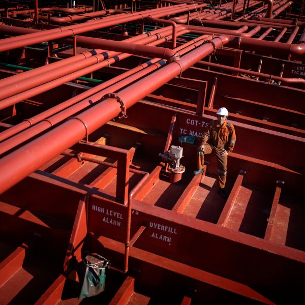 Rahil Gunawan, 55, of Indonesia, poses on the deck of the chemical tanker on which he works as a deckhand while calling at the port of Barcelona, Spain, Friday, Sept. 27, 2024. Gunawan, who has five children and has been working on cargo ships for more than 25 years, spends seven to ten months at sea per year. (AP Photo/Emilio Morenatti)