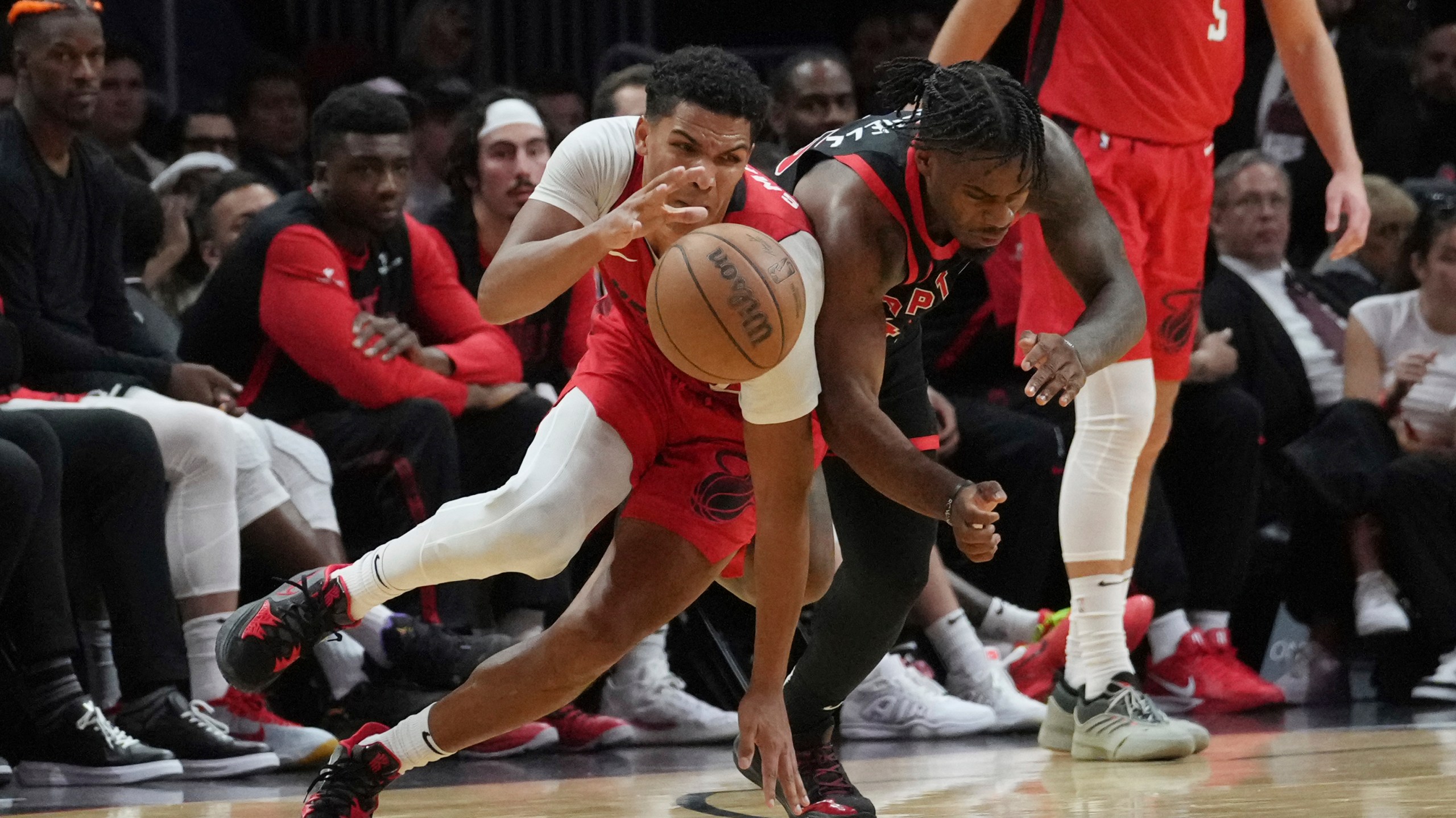 Toronto Raptors guard Davion Mitchell (45) fouls Miami Heat guard Dru Smith (12) during the second half of an NBA basketball game, Thursday, Dec. 12, 2024, in Miami. (AP Photo/Marta Lavandier)