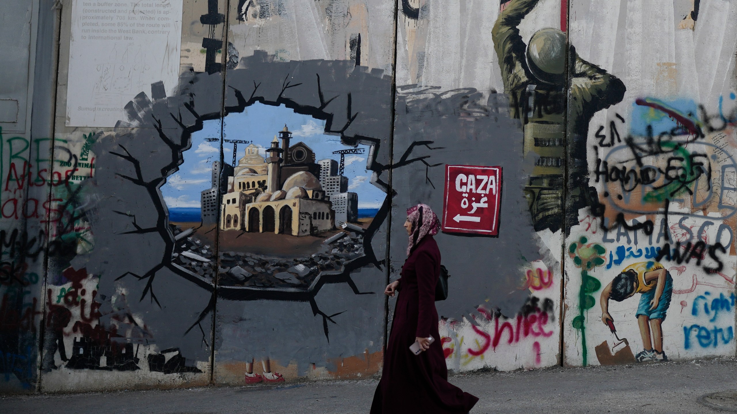 Murals cover Israel's separation barrier in the West Bank city of Bethlehem on Christmas Eve, Tuesday, Dec. 24, 2024. (AP Photo/Matias Delacroix)