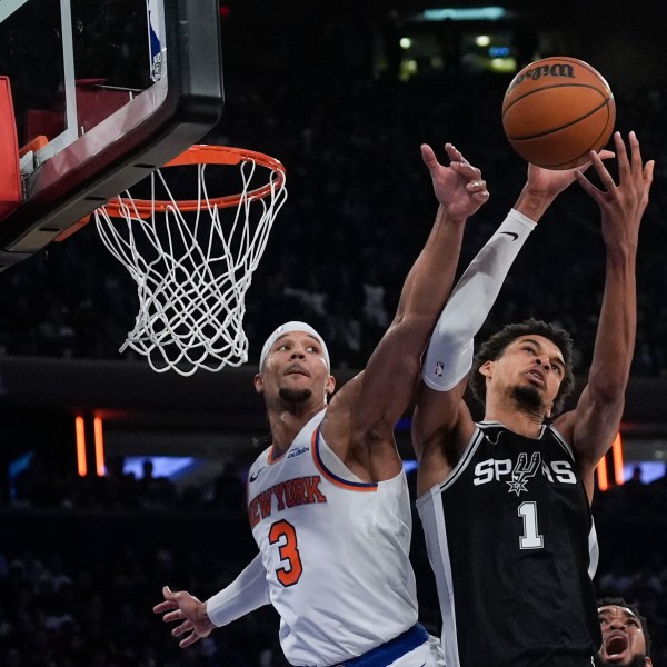 New York Knicks' Josh Hart (3), left, and San Antonio Spurs' Victor Wembanyama fight for a rebound during the second half of an NBA basketball game, Wednesday, Dec. 25, 2024, in New York. The Knicks defeated the Spurs 117-114. (AP Photo/Seth Wenig)