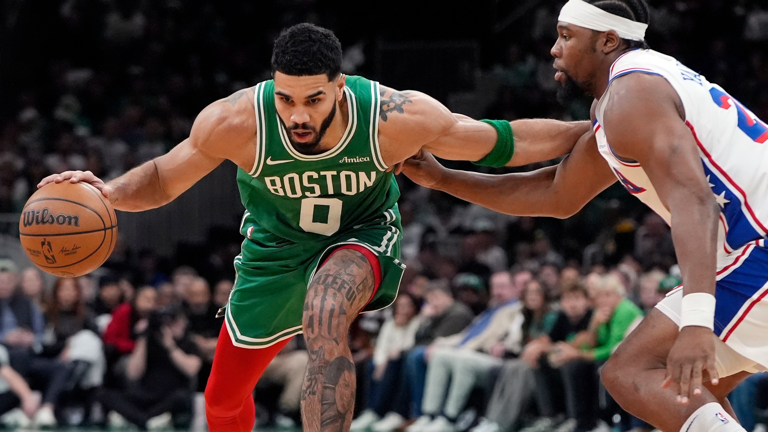 Boston Celtics' Jayson Tatum (0) drives past Philadelphia 76ers' Guerschon Yabusele during the first half of an NBA basketball game, Wednesday, Dec. 25, 2024, in Boston (AP Photo/Michael Dwyer)