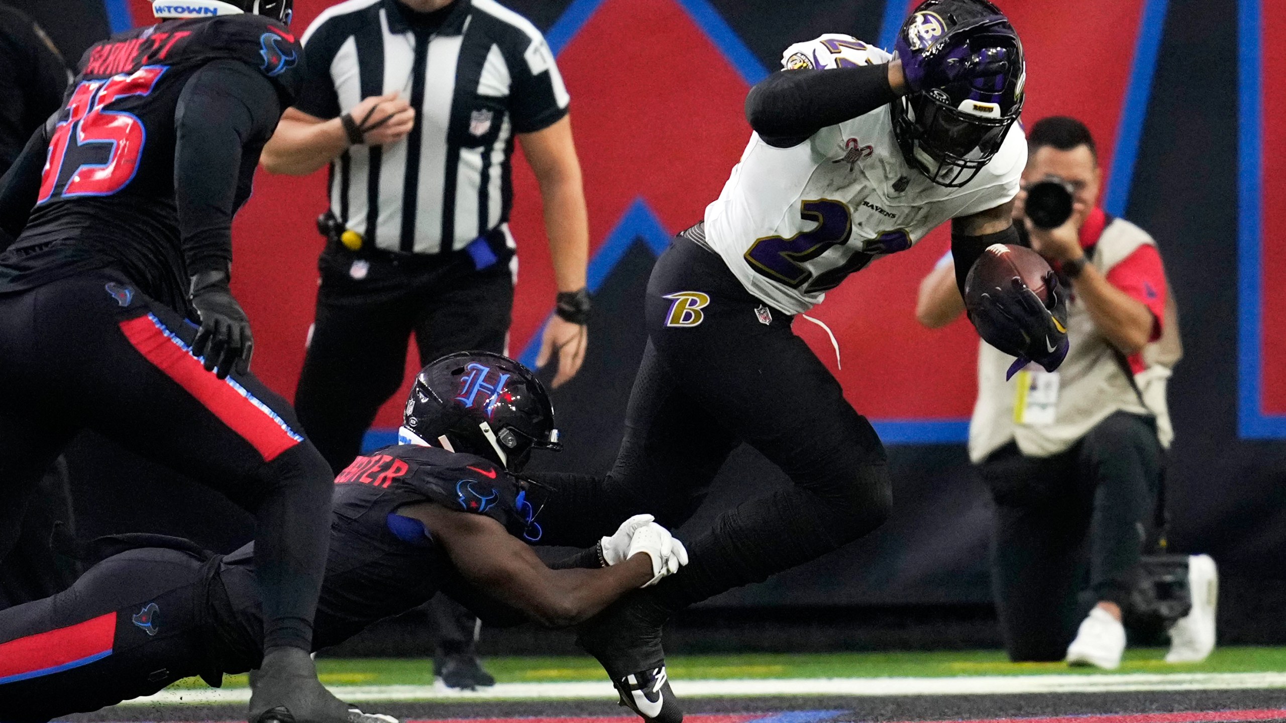 Baltimore Ravens running back Derrick Henry, right, is tackled by Houston Texans cornerback Kamari Lassiter for a safety during the first half of an NFL football game, Wednesday, Dec. 25, 2024, in Houston. (AP Photo/David J. Phillip)