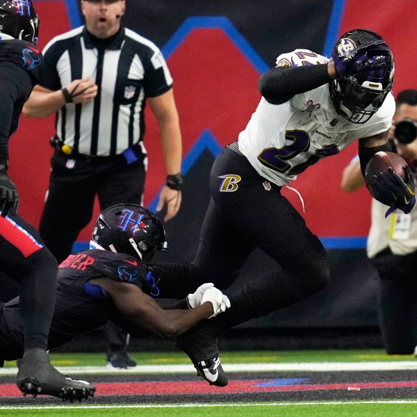 Baltimore Ravens running back Derrick Henry, right, is tackled by Houston Texans cornerback Kamari Lassiter for a safety during the first half of an NFL football game, Wednesday, Dec. 25, 2024, in Houston. (AP Photo/David J. Phillip)