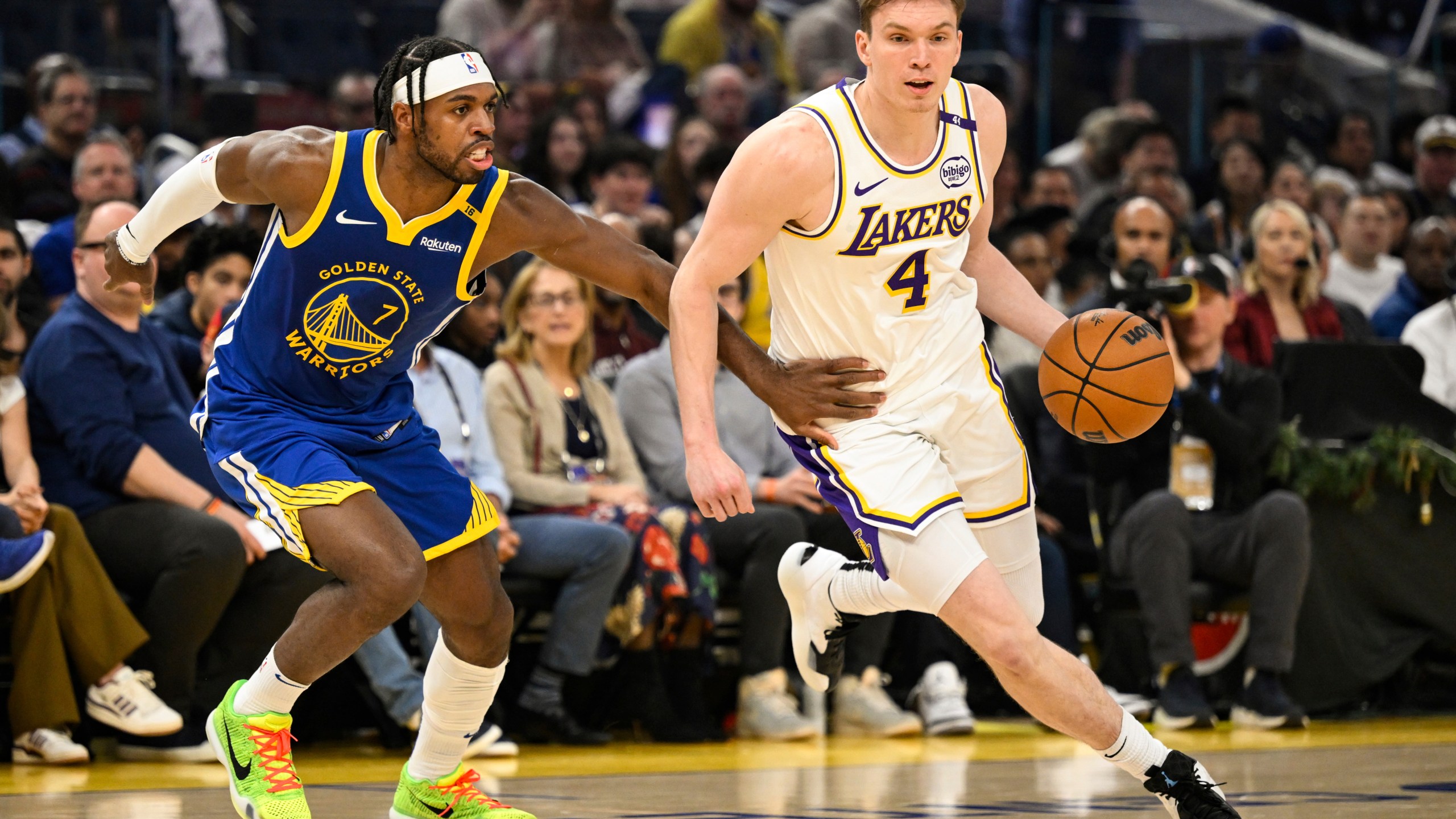 Los Angeles Lakers guard Dalton Knecht (4) dribbles against Golden State Warriors guard Buddy Hield (7) during the first half of an NBA basketball game, Wednesday, Dec. 25, 2024, in San Francisco. (AP Photo/Eakin Howard)