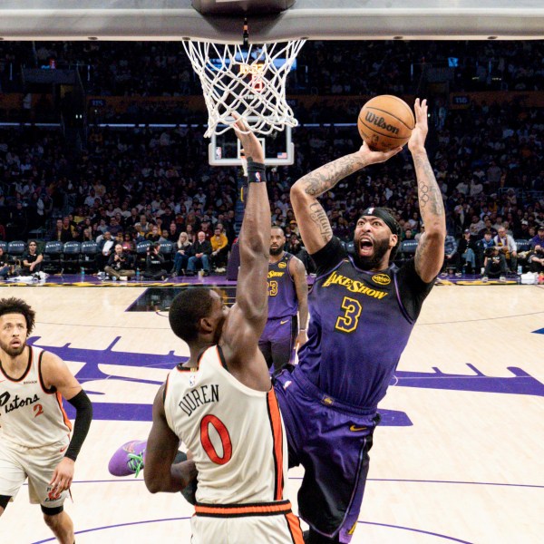 Los Angeles Lakers forward Anthony Davis (3) shoots over Detroit Pistons center Jalen Duren (0) during the second half of an NBA basketball game in Los Angeles, Monday, Dec. 23, 2024. (AP Photo/Eric Thayer)