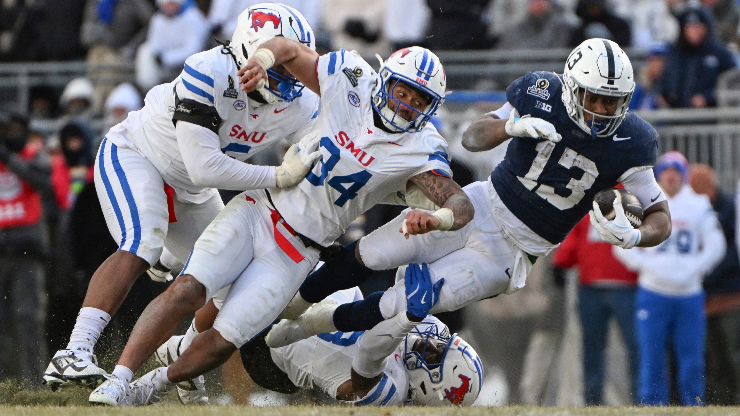 Penn State running back Kaytron Allen (13) is tackled by SMU linebacker Ahmad Walker (34) during the second half in the first round of the College Football Playoff, Saturday, Dec. 21, 2024, in State College, Pa. (AP Photo/Barry Reeger)