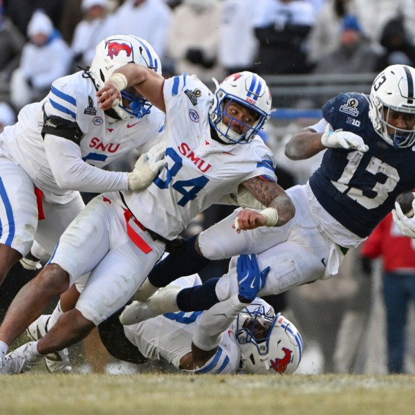 Penn State running back Kaytron Allen (13) is tackled by SMU linebacker Ahmad Walker (34) during the second half in the first round of the College Football Playoff, Saturday, Dec. 21, 2024, in State College, Pa. (AP Photo/Barry Reeger)