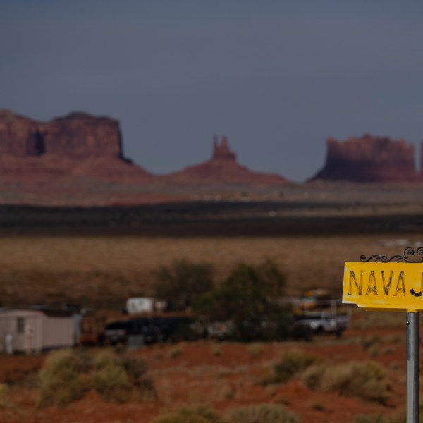 FILE - A sign marks Navajo Drive, as Sentinel Mesa stands in the distance in Oljato-Monument Valley, Utah on the Navajo Reservation, April 30, 2020. (AP Photo/Carolyn Kaster, File)