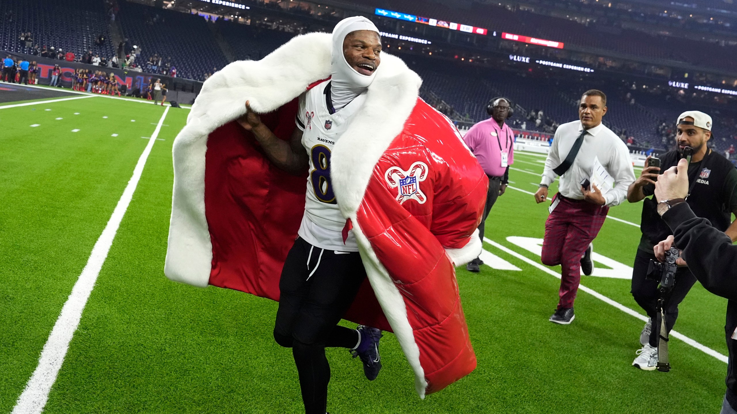 Lamar Jackson, quarterback de los Ravens de Baltimore, abandona el campo con un abrigo de Santa Claus, tras la victoria sobre los Texans de Houston, el miércoles 25 de diciembre de 2024 (AP Foto/David J. Phillip)