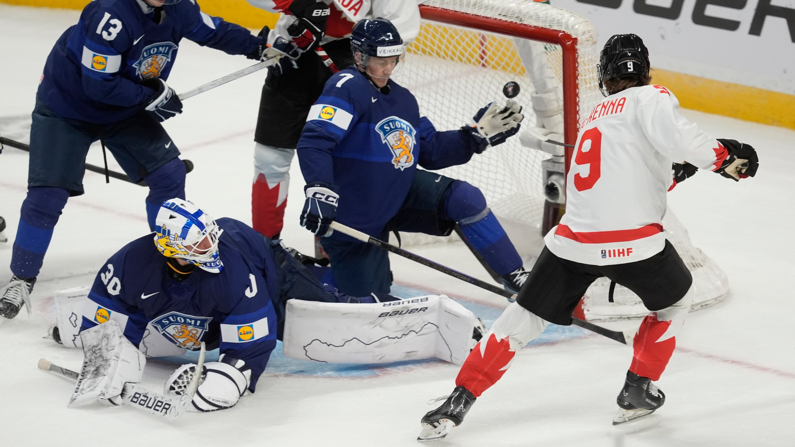 Canada forward Gavin McKenna (9) scores on Finland goaltender Petteri Rimpinen (30), as defensemen Veeti Vaisanen (13) and Daniel Nieminen (7) try to cover the net during first period IIHF World Junior Hockey Championship tournament action, Thursday, Dec. 26, 2024, in Ottawa. (Adrian Wyld/The Canadian Press via AP)