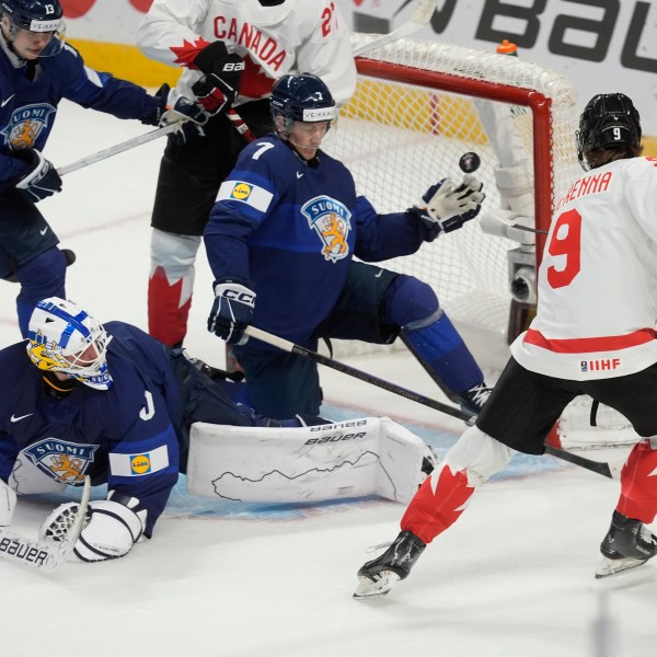 Canada forward Gavin McKenna (9) scores on Finland goaltender Petteri Rimpinen (30), as defensemen Veeti Vaisanen (13) and Daniel Nieminen (7) try to cover the net during first period IIHF World Junior Hockey Championship tournament action, Thursday, Dec. 26, 2024, in Ottawa. (Adrian Wyld/The Canadian Press via AP)