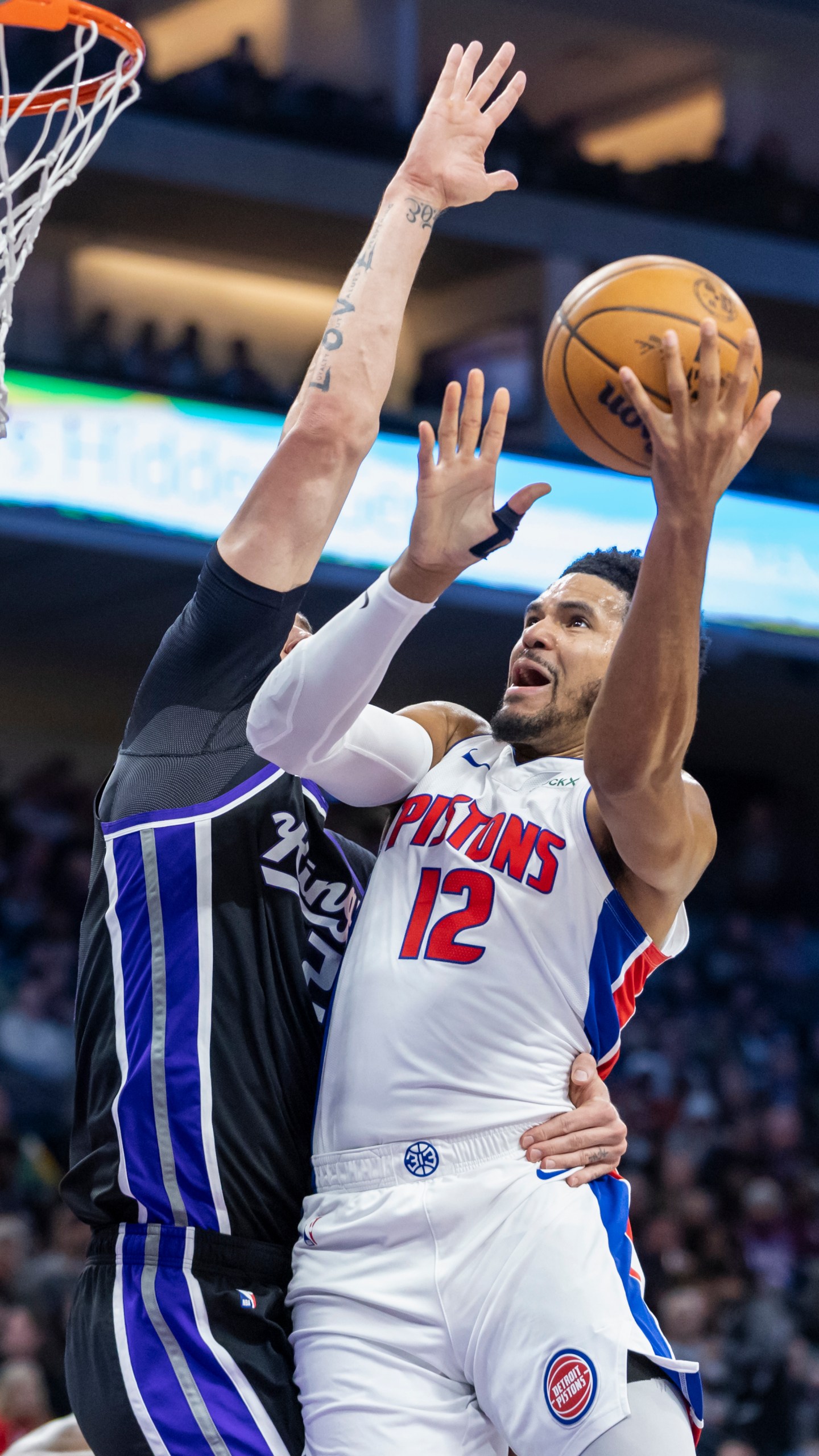 Detroit Pistons forward Tobias Harris (12) attempts a layup over Sacramento Kings center Alex Len, left, during the first half of an NBA basketball game Thursday, Dec. 26, 2024, in Sacramento, Calif. (AP Photo/Sara Nevis)