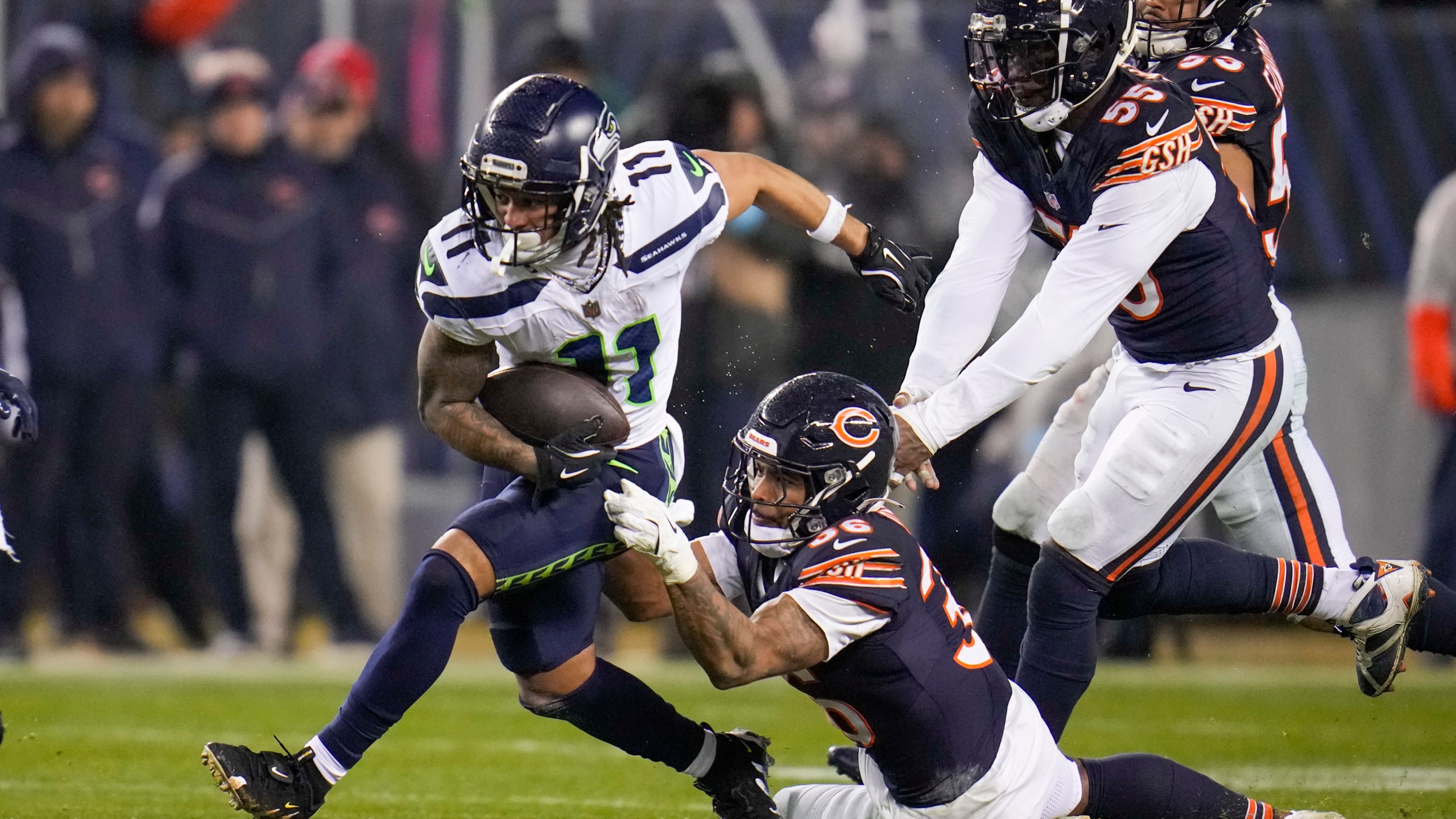 Seattle Seahawks wide receiver Jaxon Smith-Njigba (11) runs with the ball as Chicago Bears safety Jonathan Owens (36) and defensive end Jacob Martin (55) try to stop him during the second half of an NFL football game, Thursday, Dec. 26, 2024, in Chicago. (AP Photo/Erin Hooley)