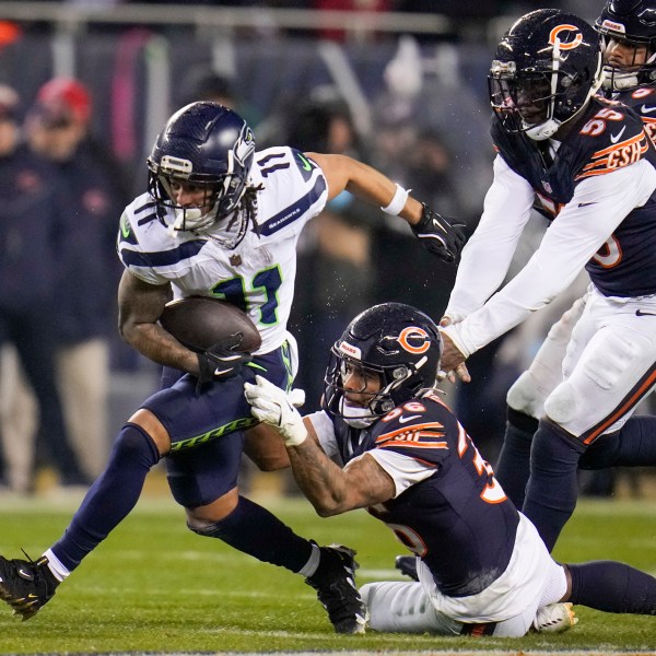 Seattle Seahawks wide receiver Jaxon Smith-Njigba (11) runs with the ball as Chicago Bears safety Jonathan Owens (36) and defensive end Jacob Martin (55) try to stop him during the second half of an NFL football game, Thursday, Dec. 26, 2024, in Chicago. (AP Photo/Erin Hooley)