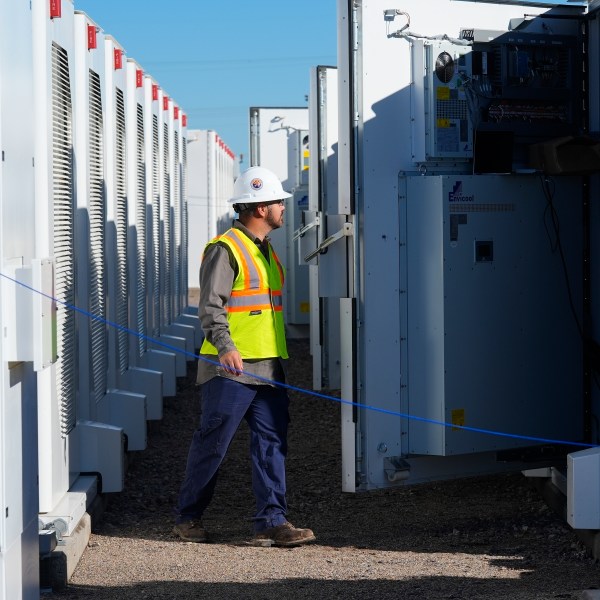 FILE - A worker does checks on battery storage pods at Orsted's Eleven Mile Solar Center lithium-ion battery storage energy facility, Feb. 29, 2024, in Coolidge, Ariz. (AP Photo/Ross D. Franklin, File)