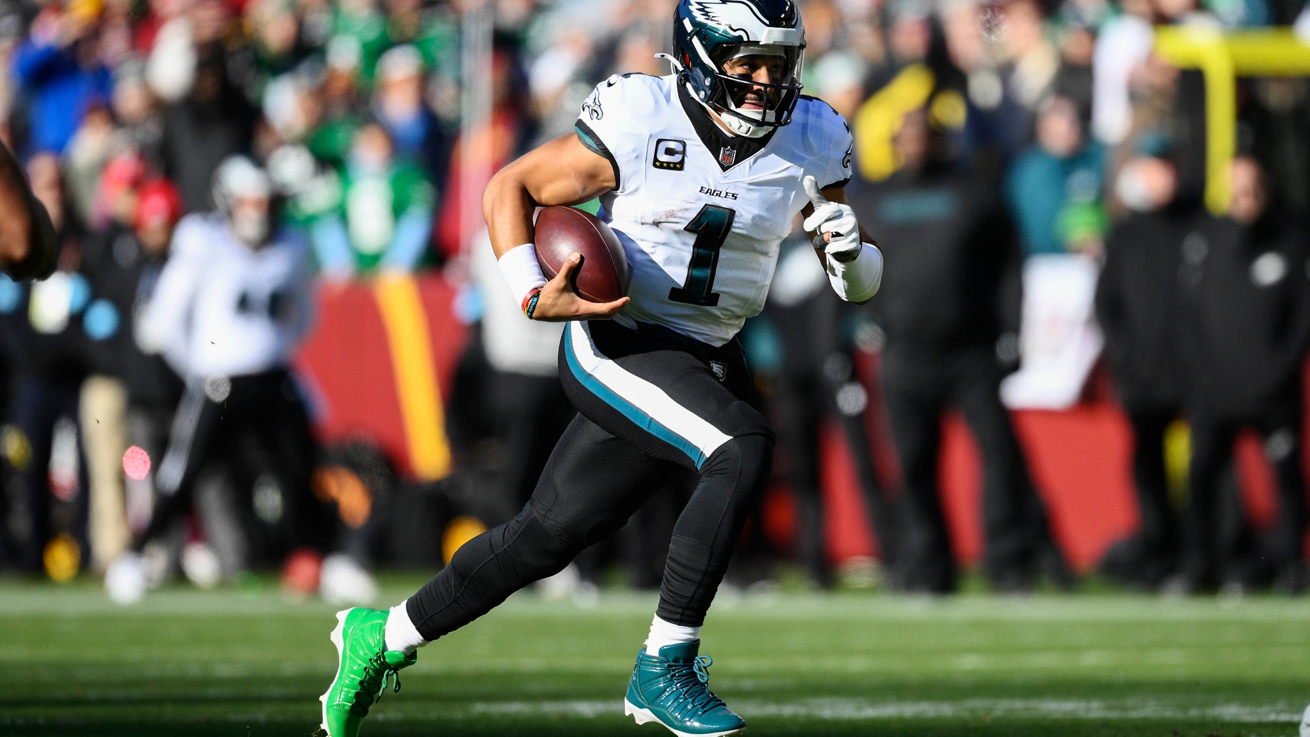 Philadelphia Eagles quarterback Jalen Hurts (1) runs with the ball during the first half of an NFL football game against the Washington Commanders, Sunday, Dec. 22, 2024, in Landover, Md. (AP Photo/Nick Wass)