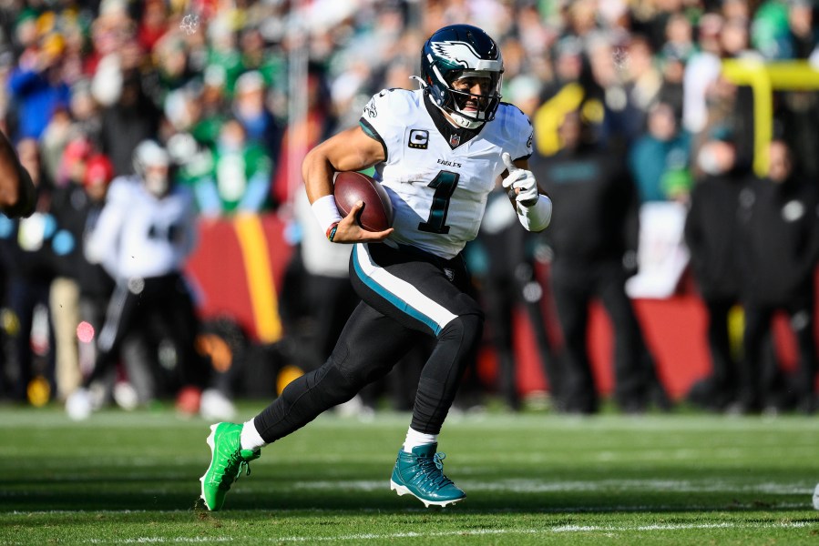 Philadelphia Eagles quarterback Jalen Hurts (1) runs with the ball during the first half of an NFL football game against the Washington Commanders, Sunday, Dec. 22, 2024, in Landover, Md. (AP Photo/Nick Wass)