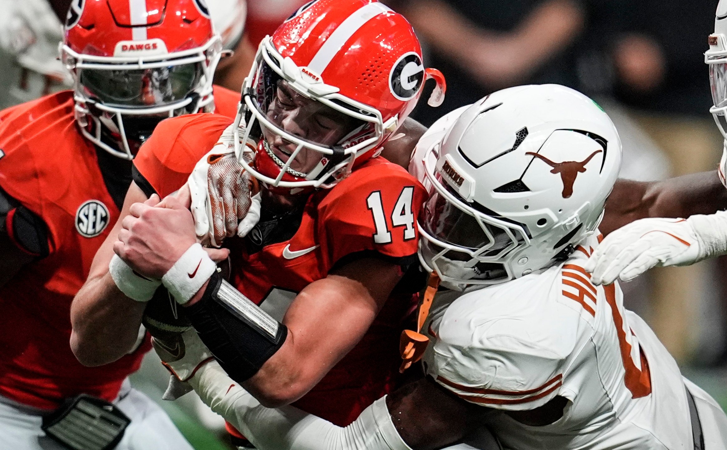 Texas linebacker Anthony Hill Jr. (0) hits Georgia quarterback Gunner Stockton (14) during the second half of the Southeastern Conference championship NCAA college football game, Saturday, Dec. 7, 2024, in Atlanta. (AP Photo/Mike Stewart)