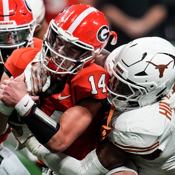 Texas linebacker Anthony Hill Jr. (0) hits Georgia quarterback Gunner Stockton (14) during the second half of the Southeastern Conference championship NCAA college football game, Saturday, Dec. 7, 2024, in Atlanta. (AP Photo/Mike Stewart)