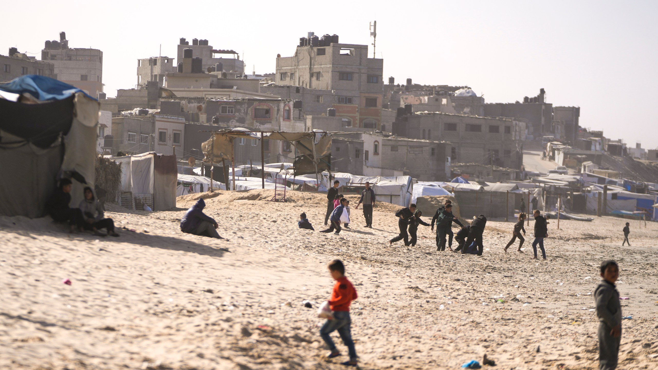 Children play on the sand in a camp for internally displaced Palestinians at the beachfront in Deir al-Balah, central Gaza Strip, Friday, Dec. 27, 2024. (AP Photo/Abdel Kareem Hana)