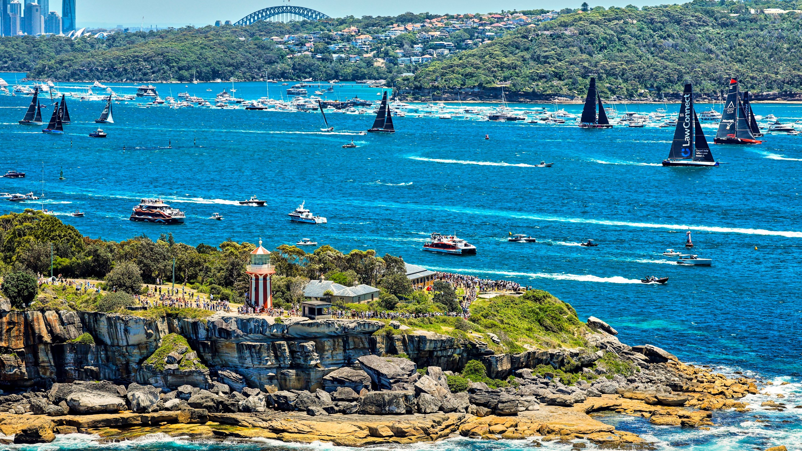 In this photo provided by Rolex, competitors sail towards the heads as they leave Sydney Harbour at the start of the Sydney to Hobart yacht race in Sydney, Thursday, Dec. 26, 2024. (Carlo Borlenghi/Rolex via AP)