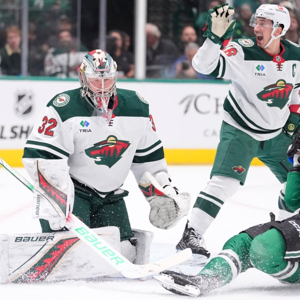 Dallas Stars left wing Mason Marchment (27) falls to ice as Minnesota Wild defenseman Jared Spurgeon (46) calls for an end to play after Marchment was hit by a puck in front of Wild goaltender Filip Gustavsson (32) during the first period of an NHL hockey game Friday, Dec. 27, 2024, in Dallas. (AP Photo/LM Otero)